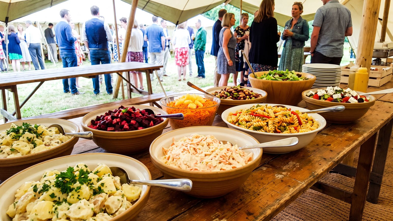 Braai salads on a trestle table: potato salad, beetroot, coleslaw, carrot, pasta salad and Greek salad