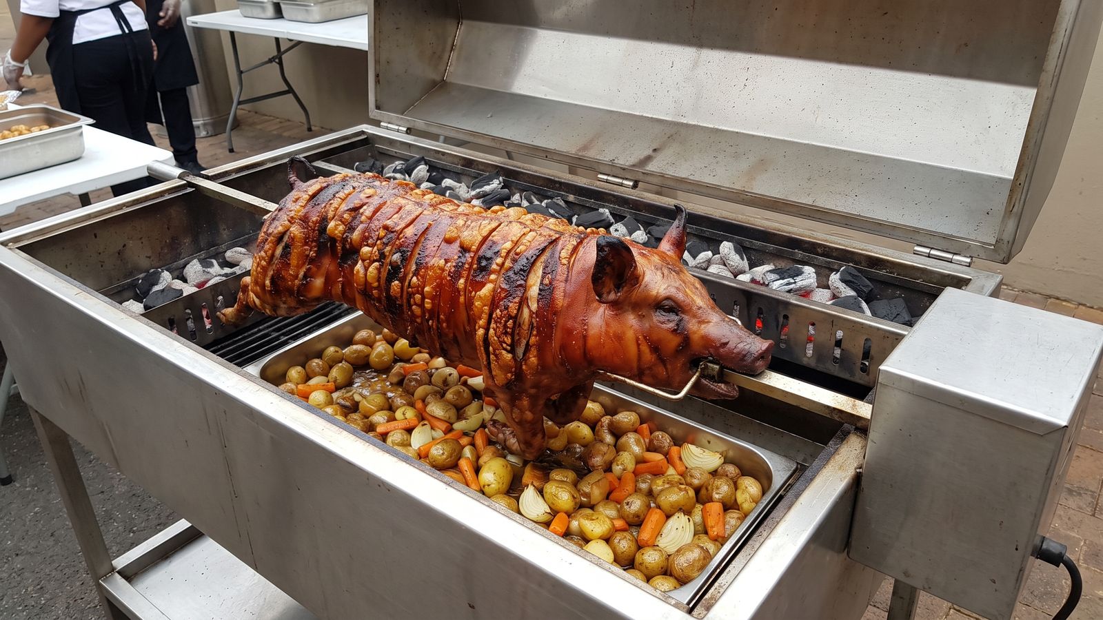 How to make crackling: blistered, scored pork skin on a whole pig turning on a spit braai machine