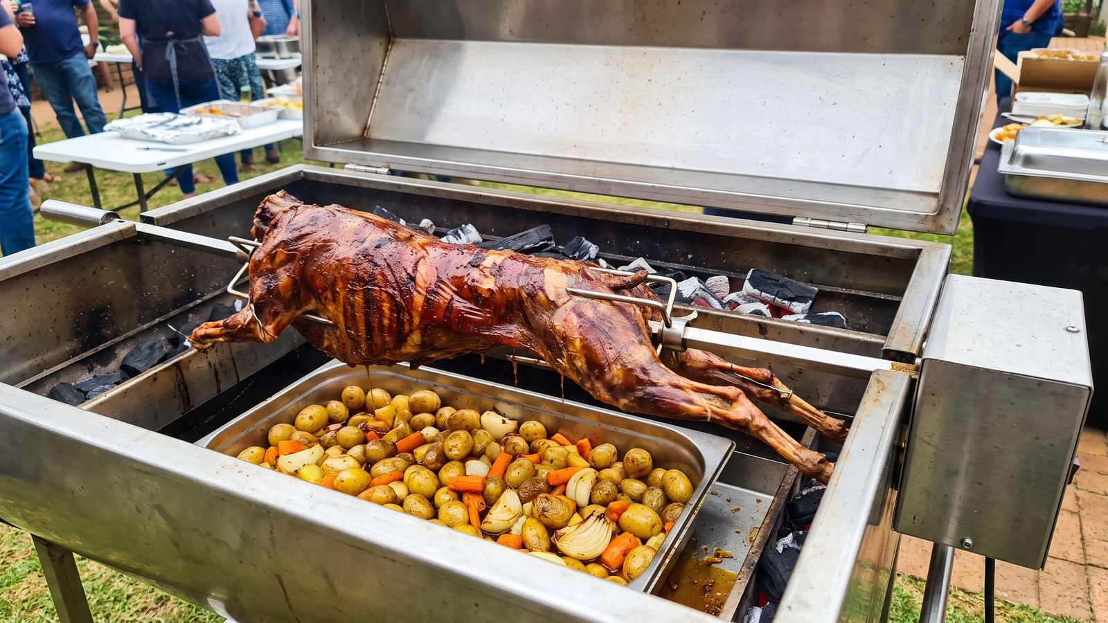 Lamb spit braai: a whole lamb clamped to the spit with its legs wired, turning over glowing coals